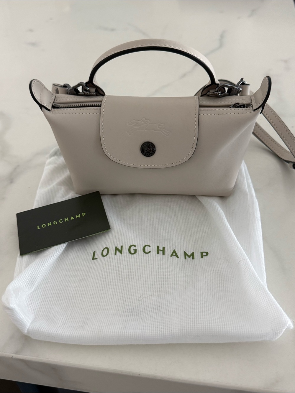 Longchamp Extra Small Le Pilage leather clutch with strap in light beig
